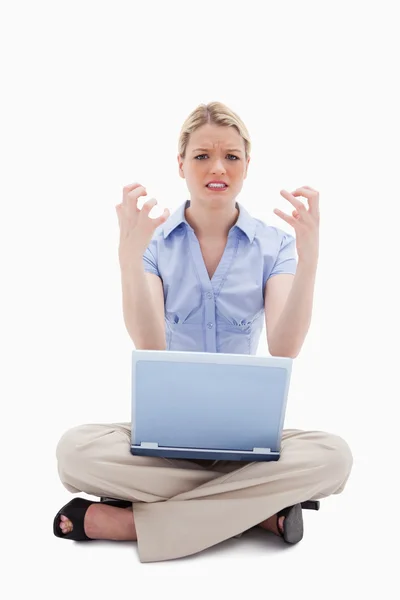Sittande kvinna arg över hennes laptop — Stockfoto