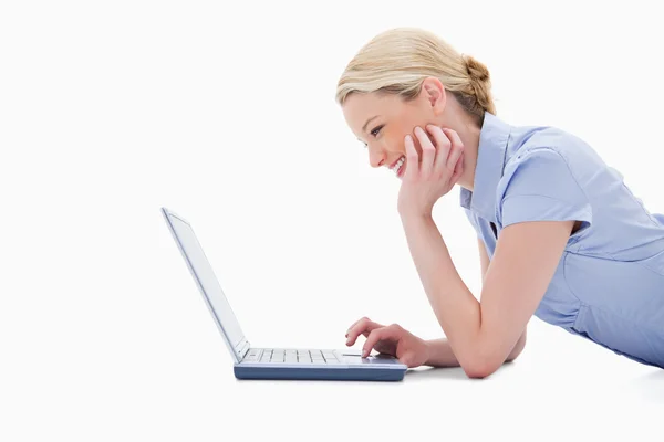 微笑的女人用她的笔记本电脑的侧面图 — 图库照片