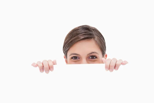 Woman having a look over blank wall — Stock Photo, Image