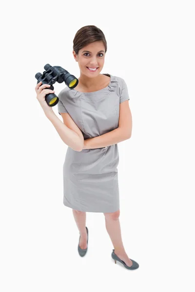 Woman standing with binoculars — Stockfoto