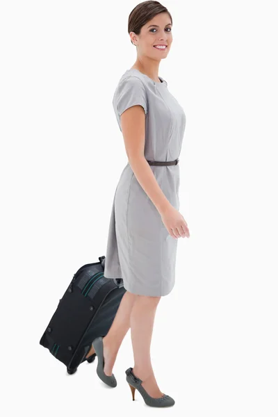 Side view of smiling woman with wheely bag — Stock Photo, Image