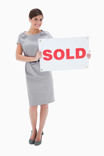 Woman holding sold sign in her hands — Stock Photo, Image