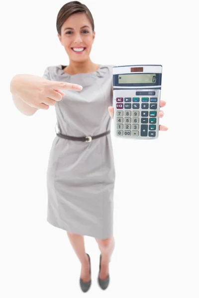 Mulher apontando para calculadora de mão — Fotografia de Stock