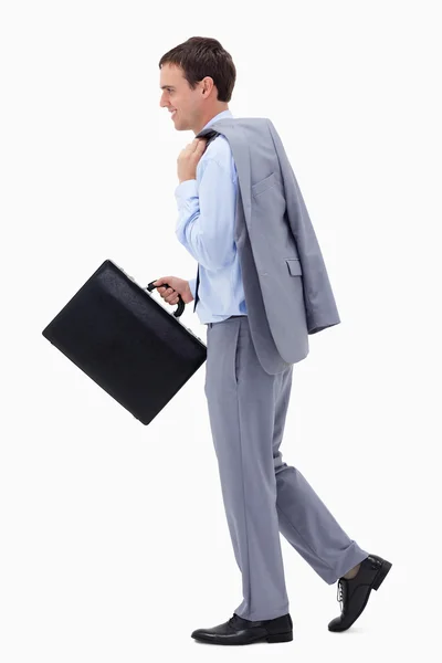 Side view of walking and smiling businessman with suitcase — Stock Photo, Image