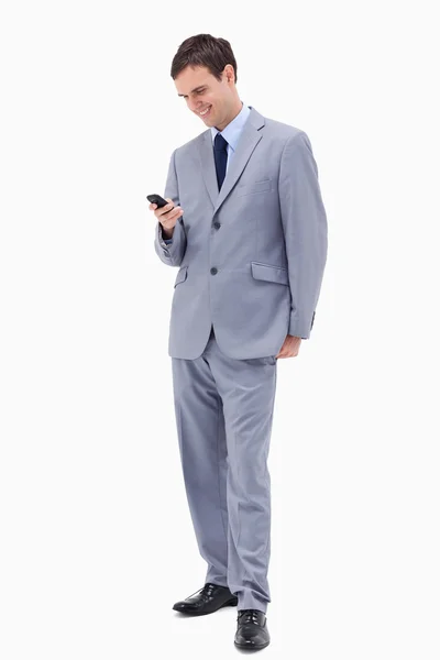 Sonriente hombre de negocios leyendo mensaje de texto — Foto de Stock