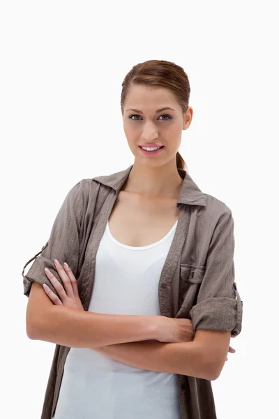 Uśmiechnięta kobieta stojąca ze złożonymi ramionami — Zdjęcie stockowe