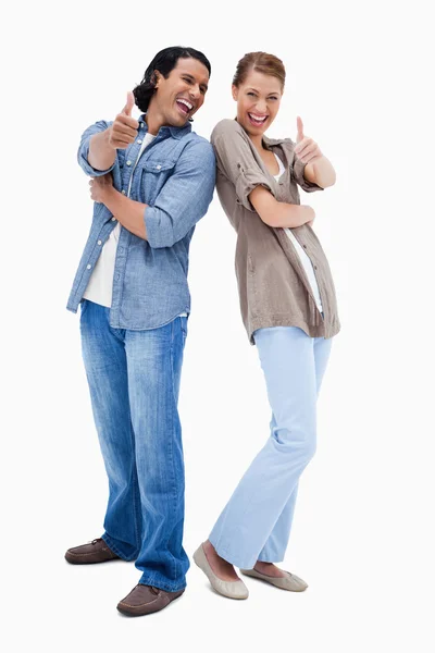 Sorridente giovane coppia dando pollici in su — Foto Stock