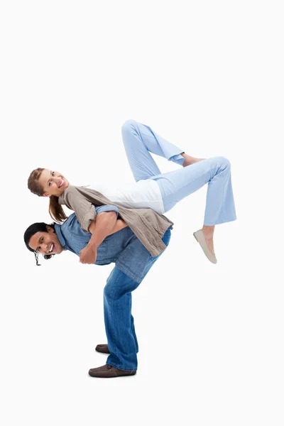 Мужчина поднимает свою девушку на спину — стоковое фото