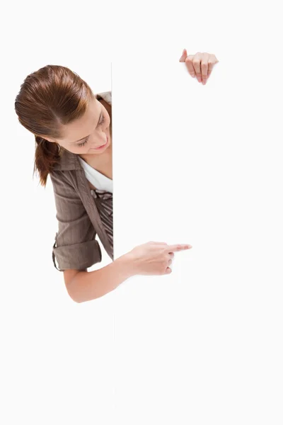 Woman wijzend rond leeg teken — Stockfoto