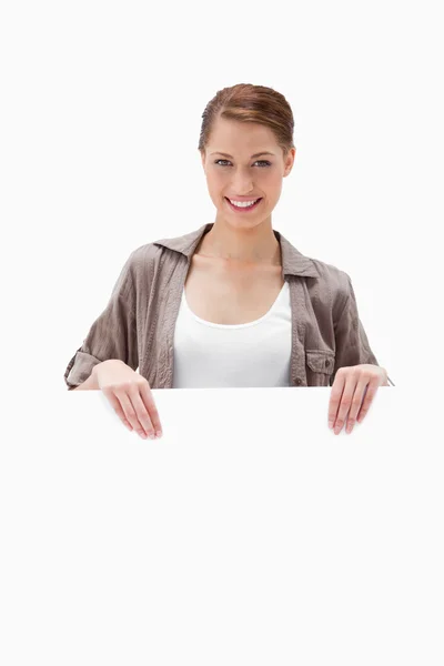 Mujer sonriente sosteniendo letrero en blanco — Foto de Stock