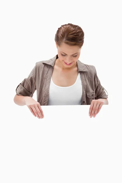 Woman looking down at blank signboard — Stock Photo, Image