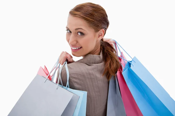 Arkadan görünüşü alışveriş torbaları ile gülümseyen kadın — Stok fotoğraf