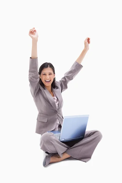 Cheering donna seduta con computer portatile — Foto Stock