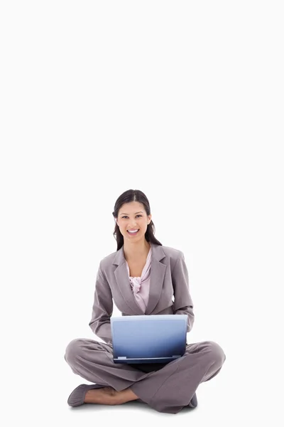 Uśmiechnięta kobieta siedząca z laptopem — Zdjęcie stockowe