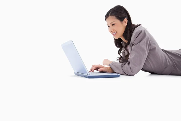 Zijaanzicht van liegen vrouw met laptop — Stockfoto