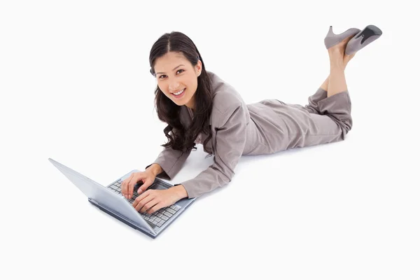 Vrouw met haar laptop liegen — Stockfoto