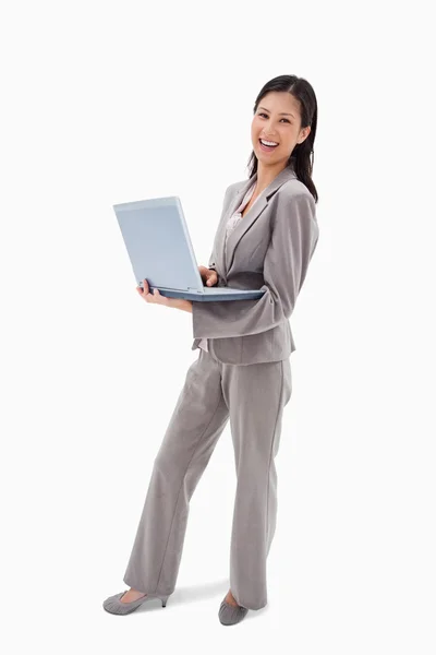 Вид сбоку на смеющуюся деловую женщину с ноутбуком — стоковое фото