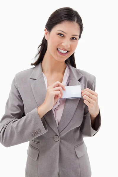 Mujer de negocios sonriente poniéndose la insignia del nombre — Foto de Stock