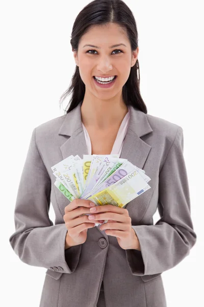 Mujer de negocios sonriente con billetes de banco en sus manos —  Fotos de Stock