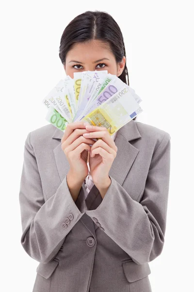 Businesswoman hiding face behind money — Stock Photo, Image
