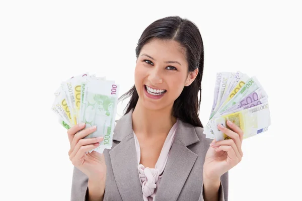 Leende affärskvinna håller pengarna i hennes händer — Stockfoto