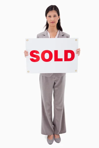 Real estate agent holding sold sign — Stock Photo, Image