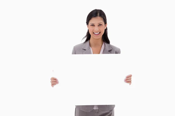 Smiling businesswoman with blank sign board — Stock Photo, Image