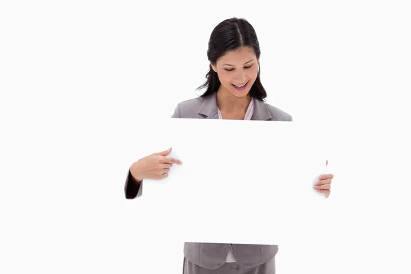 Affärskvinna tittar och pekar på tomma tecken styrelse — Stockfoto