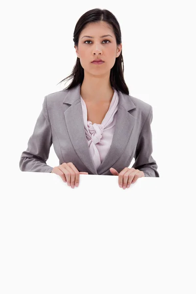 Serious looking businesswoman with blank sign board — Stock Photo, Image