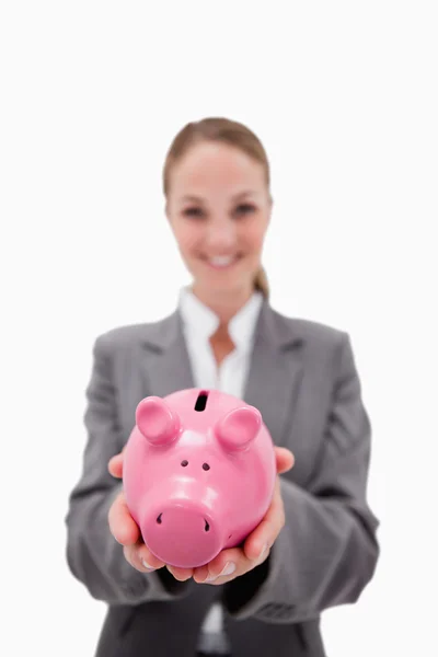 Банк для свиней удерживается улыбающимся сотрудником банка — стоковое фото