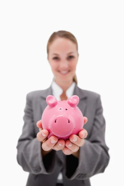 Piggy banco sendo oferecido por empregado do banco sorrindo — Fotografia de Stock