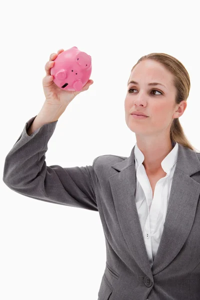 Bankangestellte nimmt Sparschwein unter die Lupe — Stockfoto
