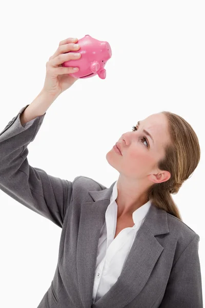 Bank werknemer op zoek bij piggy bank — Stockfoto