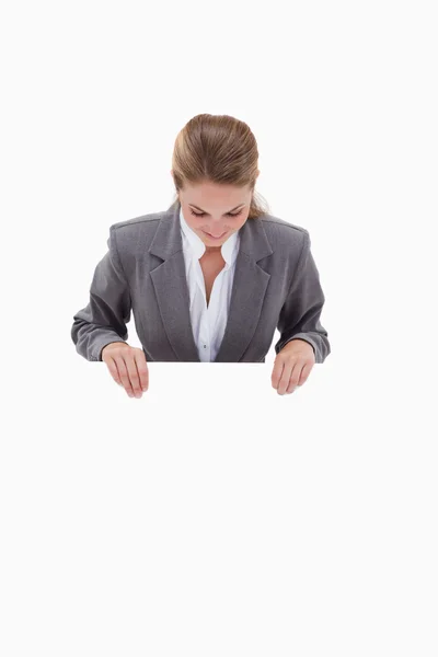 Bank employee looking down at blank sign in her hands — Stock Photo, Image