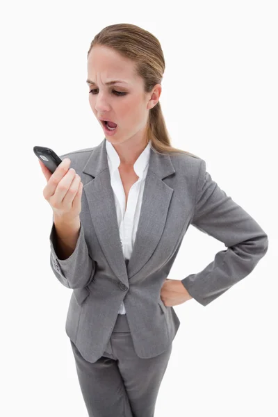 Indignant looking bank employee reading text message — Stock Photo, Image