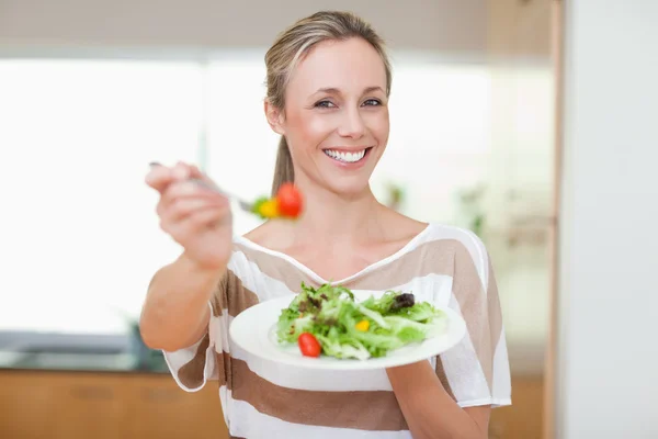 Frau bietet gesunden Salat an lizenzfreie Stockbilder