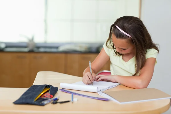 Girl doing homework in the kitchen Royalty Free Stock Images
