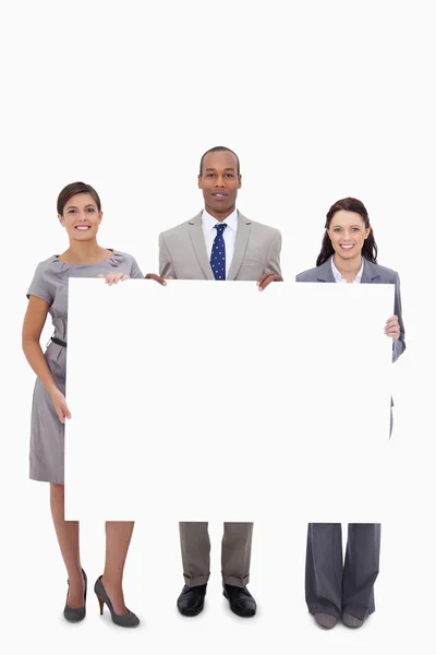Businesspeople holding blank sign — Stock Photo, Image