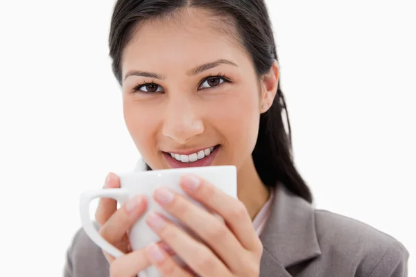 Sonriente mujer de negocios sosteniendo la taza cerca Imagen de stock