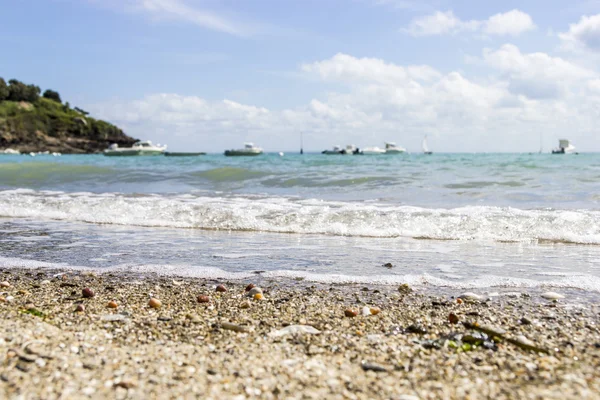山、ボート、ブルに対する実行中の波と小石のビーチ — ストック写真