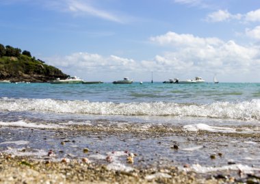 dağ, deniz araçları ve blu karşı çalışan bir dalga ile çakıl plajı