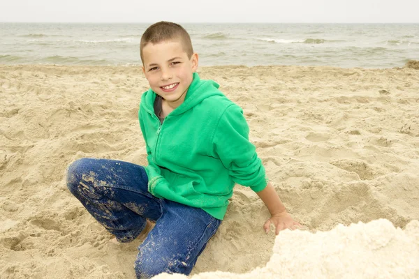 Lindo niño jugando en la arena en la playa, costa del Mar del Norte —  Fotos de Stock