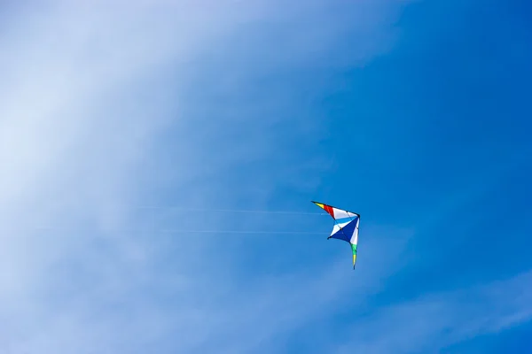 Красочный змей, парящий в красивом голубом небе — стоковое фото