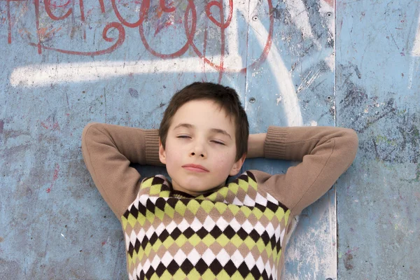 Portret ładny chłopiec relaksujący na placu zabaw — Zdjęcie stockowe