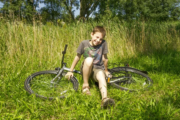 草のバイクに座っている少年 — ストック写真