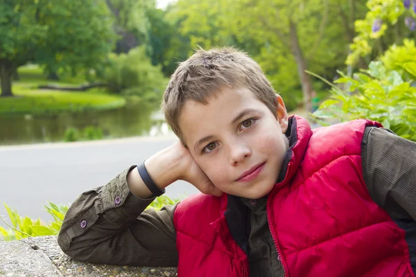 Yeşil arka planı gülümseyen sevimli genç çocuk — Stok fotoğraf