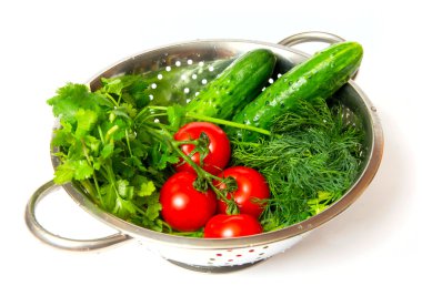 Cucumbers. red tomatoes and green arugula in a metal pan clipart