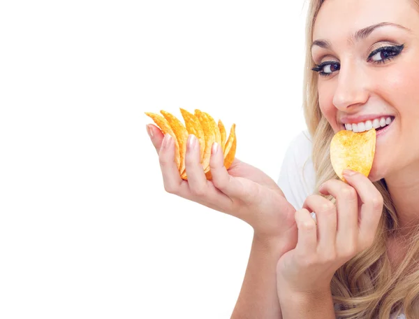 Young woman eating chips, studio-shot — Stock Photo, Image