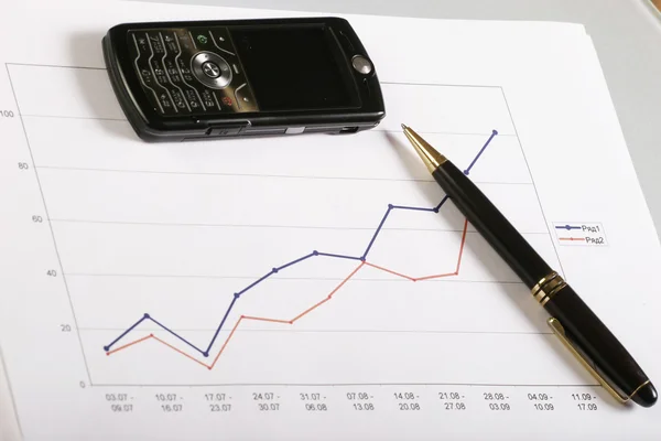 Gráficos de documentos com caneta e celular — Fotografia de Stock