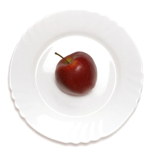 Red apple on white plate — Stock Photo, Image